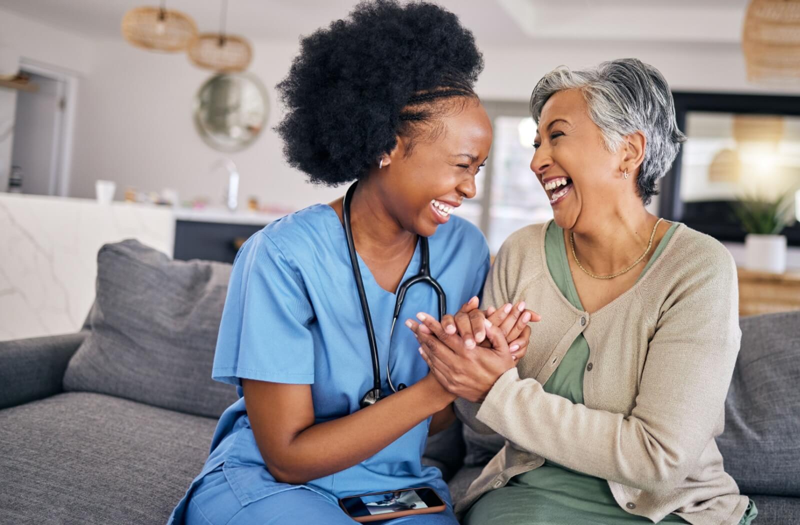 A senior resident laughing with a caregiver in assisted living in Wisconsin.