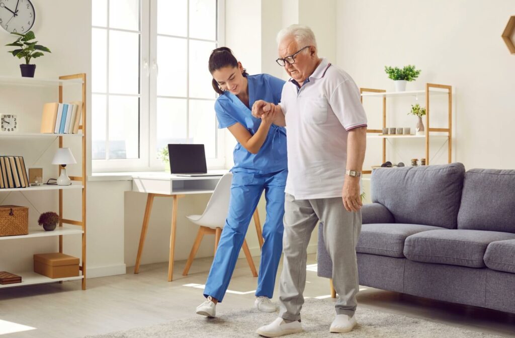 A senior resident being assisted with mobility by a caregiver in an assisted living facility in Wisconsin.