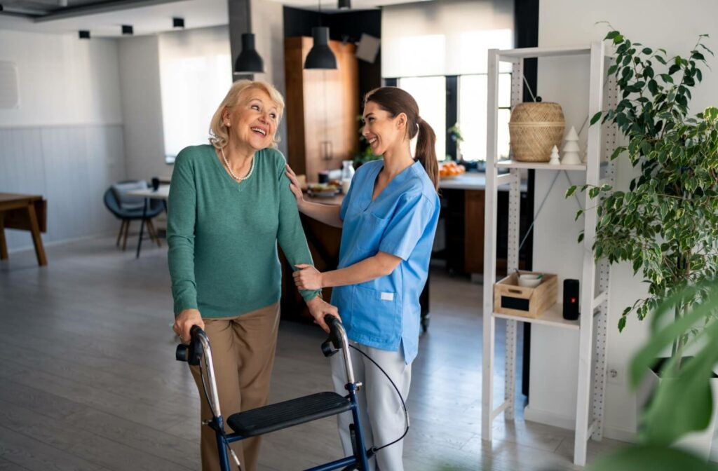 Person using a walker with support from a caregiver in a bright and home-like space